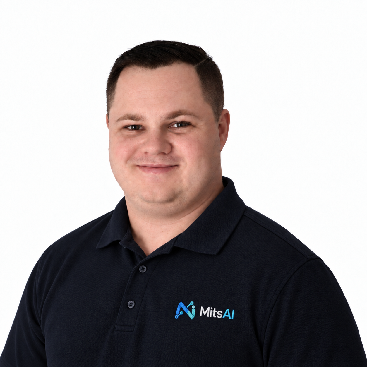 Micheal Thompson wearing a navy polo shirt with the blue and cyan MitsAI logo